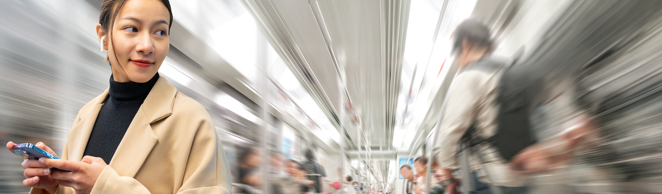 Frau mit Smartphone in moderner U-Bahn unterwegs