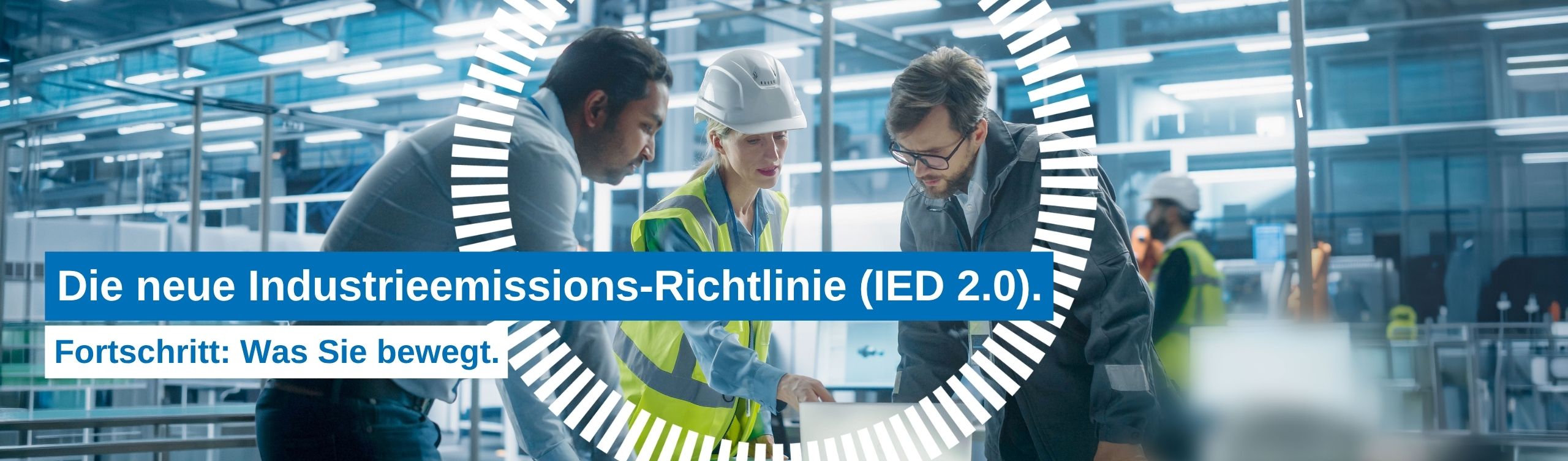 Drei Fachkräfte stehen zusammen an einem Laptop und besprechen Arbeitsabläufe in einer industriellen Umgebung.