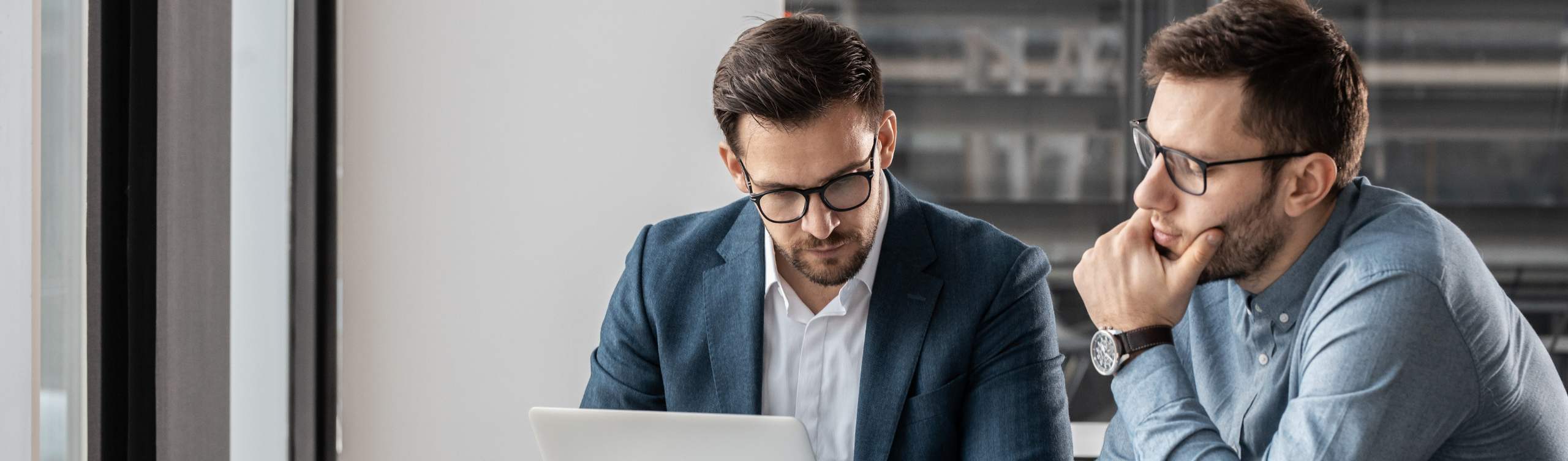 男性二人がPCをみながら打ち合わせをしている