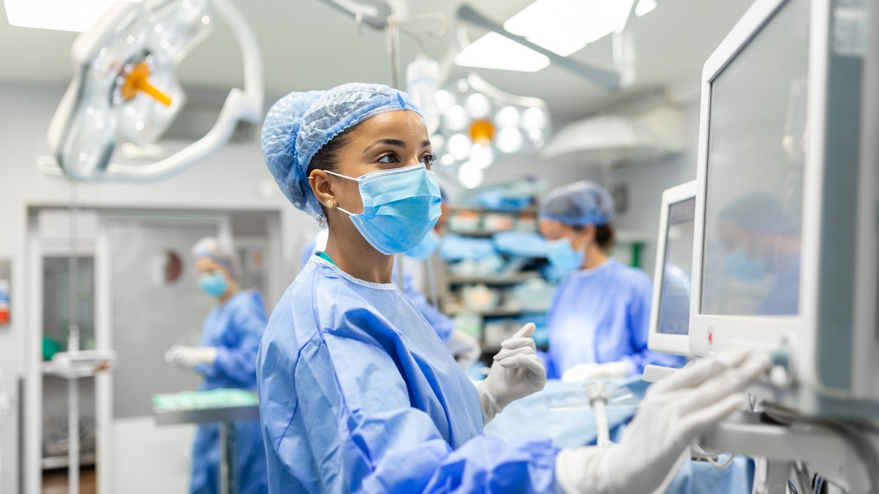 Nurse working on a medical device in an operating room