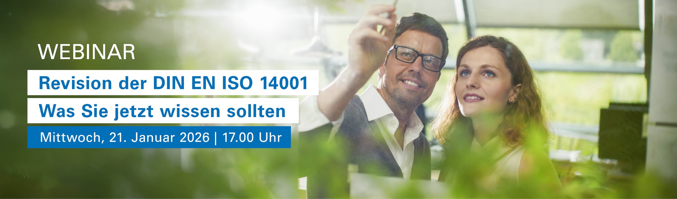 Zwei Personen in einem fachlichen Austausch zu Umweltmanagement in einem lichtdurfluteten Büro mit einer Reihe von Grünpflanzen.