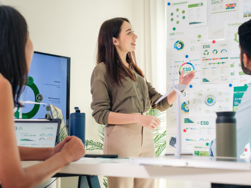 Femme présentant devant un tableau de conférence