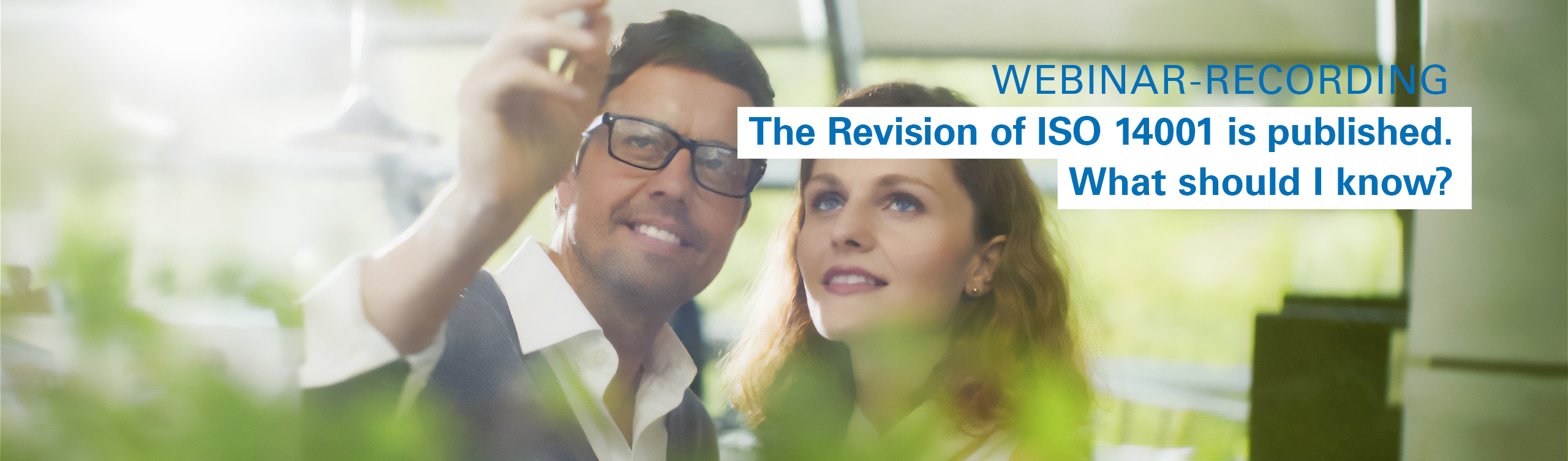 A man and a woman are reviewing the upcoming changes to ISO 14001 planned for 2026.