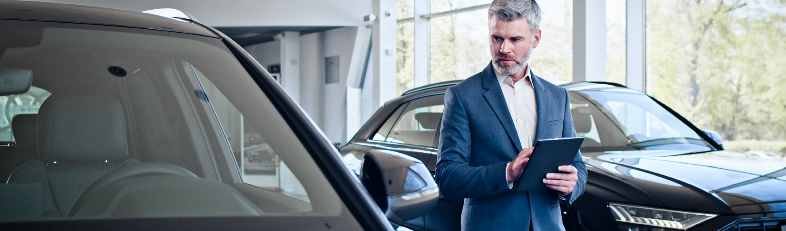 Autoverkäufer im Verkaufsraum neben Autos