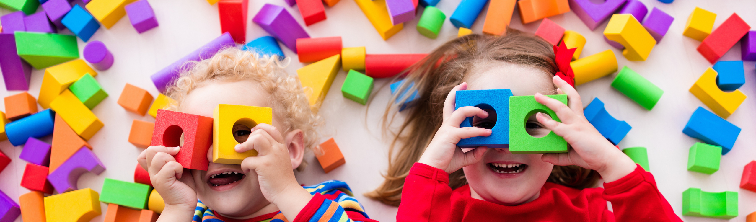 Zwei Kinder spielen mit Holzklötzen.
